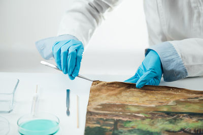Restoring oil painting canvas. restoration expert revitalizing crumpled canvas