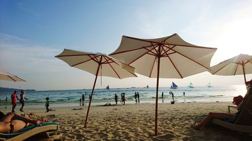 People at beach against sky