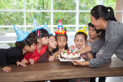 Teacher and students celebrating birthday in classroom at school