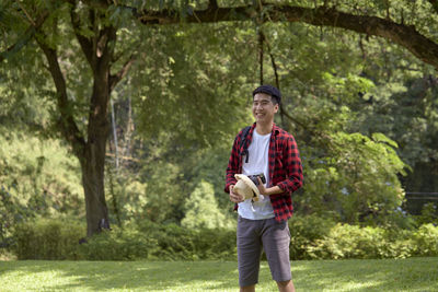 Full length of a young man standing against trees