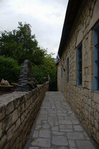 Footpath amidst buildings against sky