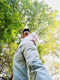 Low angle view of man standing against trees