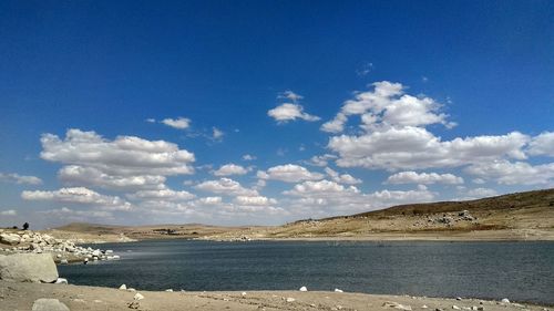 Scenic view of beach against blue sky