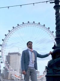 Portrait of man with ferris wheel in city