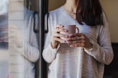 Midsection of woman holding coffee cup