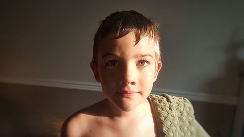 Close-up portrait of shirtless boy at home