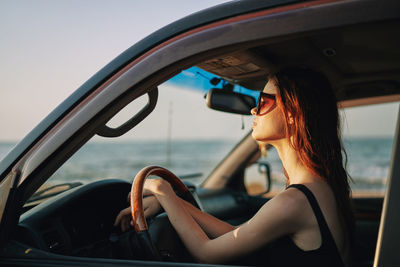 Side view of woman sitting in car