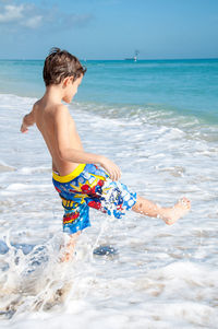 Boy playing on shore at beach