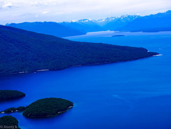 Scenic view of sea and mountains against sky