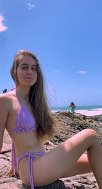 Portrait of smiling woman on beach against sky