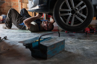 Man repairing car in garage