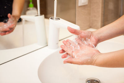 Midsection of woman in water at home