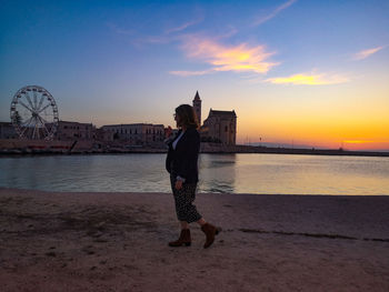 Full length of woman standing against sky during sunset