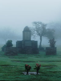 Tombstones in cemetery against clear sky