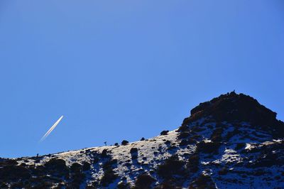 Low angle view of vapor trail against clear blue sky