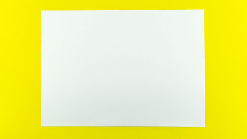 Low angle view of empty paper against yellow background