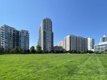 Buildings in city against clear blue sky