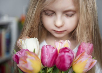 Close-up portrait of girl with pink tulips