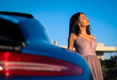 Beautiful woman with eyes closed standing against clear blue sky