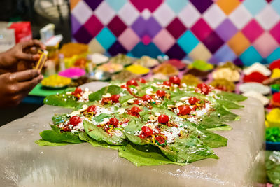 Close-up of hand holding vegetables on table