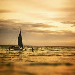 Boats in sea at sunset