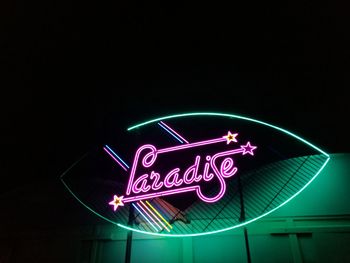 Low angle view of illuminated neon sign at night