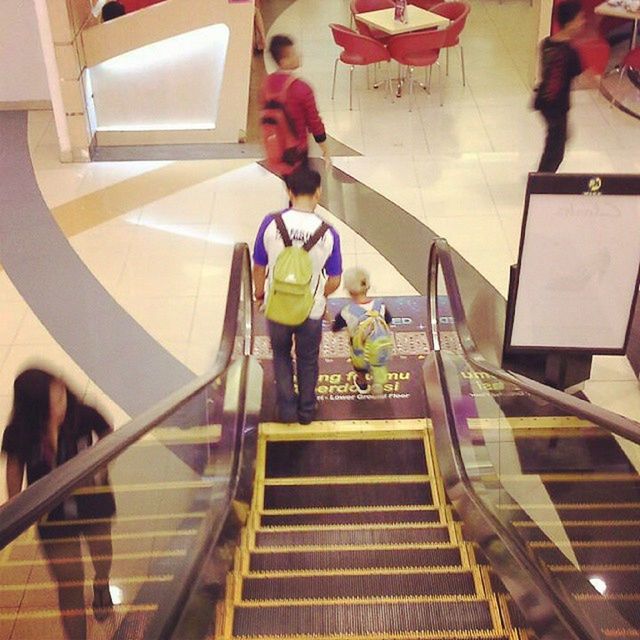 indoors, steps, steps and staircases, staircase, lifestyles, full length, built structure, architecture, escalator, men, railing, walking, leisure activity, high angle view, casual clothing, person, ceiling, incidental people