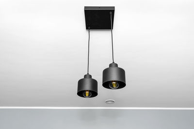 Modern chandeliers with tube shaped led bulbs, covered with matt black paint, two bulbs visible.