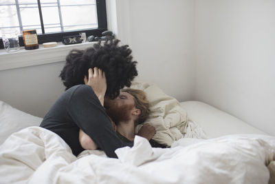 A young couple kissing in bed