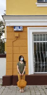 Full length of woman standing against building