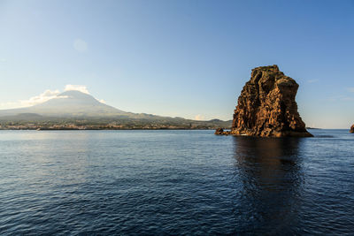 Rock formation in sea against sky