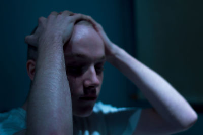 Close-up of young man holding head