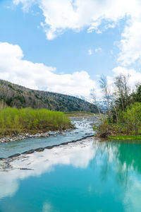 Scenic view of swimming pool by lake against sky