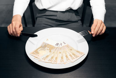 Midsection of person holding ice cream in plate