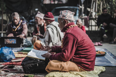 Side view of people sitting outdoors