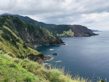 Scenic view of sea and mountains against sky