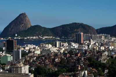 Aerial view of city by sea against clear sky