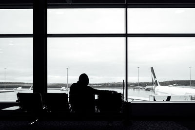 Silhouette man on seat at airport