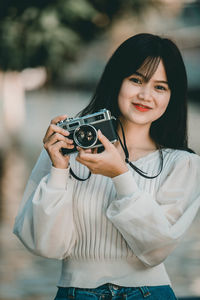 Portrait of beautiful young woman photographing