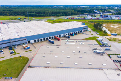 Aerial drone view of group of large modern industrial warehouse or factory buildings in suburban 