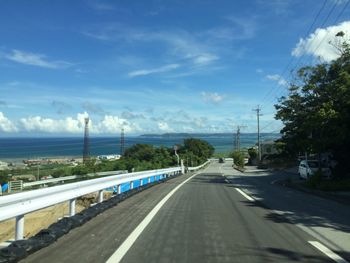 Road by street against blue sky