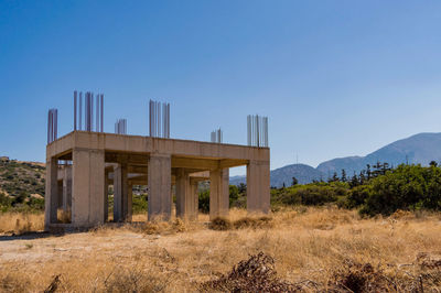 Built structure on field against clear blue sky