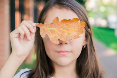 Close-up of girl holding leaf