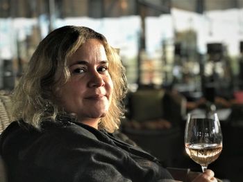 Portrait of mid adult woman having wine while sitting in restaurant