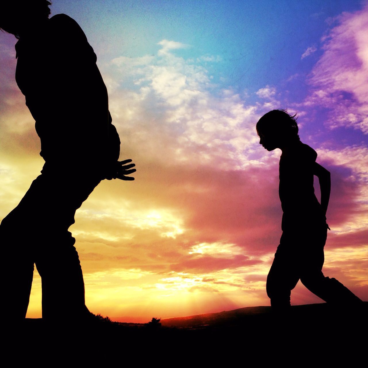 SILHOUETTE OF PERSON STANDING AGAINST CLOUDY SKY