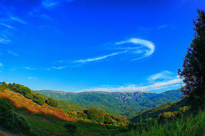 Scenic view of mountains against blue sky