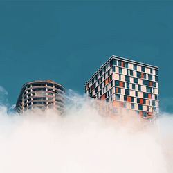 Low angle view of buildings against blue sky, colourful windows