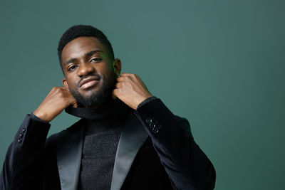 Portrait of young man against black background