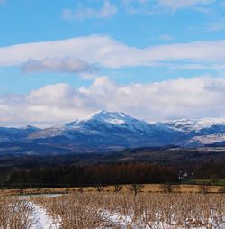 Scenic view of landscape against snowcapped mountains 