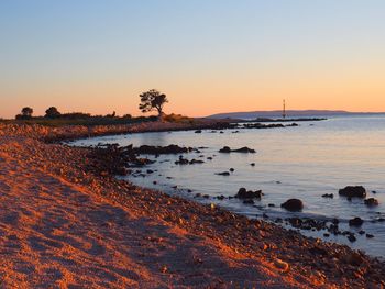 Scenic view of sea against clear sky during sunset